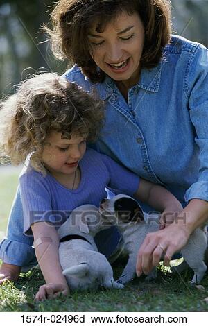 Mother and her daughter playing with puppies View Large Photo Image Stock Image - Mother and her daughter playing with puppies. Fotosearch