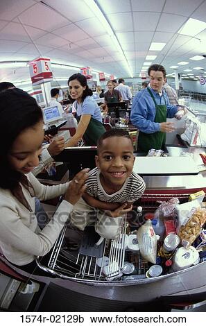 Stock Image - Mother and her son at a checkout counter in a supermarket. Fotosearch