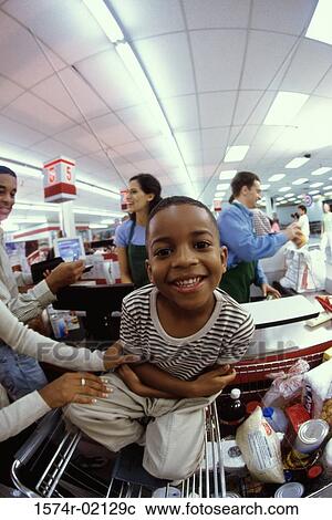 Stock Image - Mother and her son at a checkout counter in a supermarket. Fotosearch