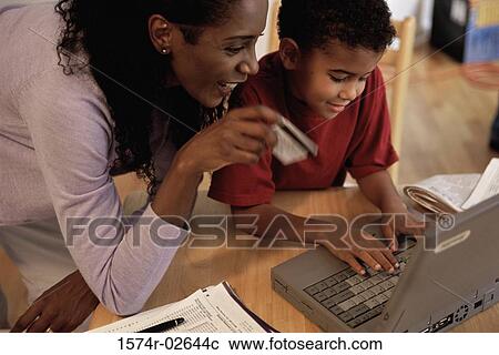 Mother and her son in front of a laptop View Large Photo Image Stock Image - Mother and her son in front of a laptop. Fotosearch