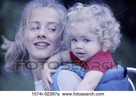 Mother carrying her daughter on her back View Large Photo Image Stock Image - Mother carrying her daughter on her back. Fotosearch