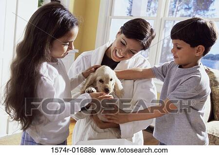 Mother holding a puppy with her son and daughter View Large Photo Image Stock Image - Mother holding a puppy with her son and daughter. Fotosearch