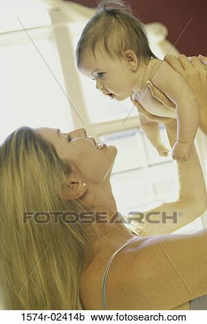 Mother holding up her baby boy View Large Photo Image Stock Image - Mother holding up her baby boy. Fotosearch