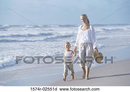 Mother walking with her daughter on the beach View Large Photo Image Stock Image - Mother walking with her daughter on the beach. Fotosearch