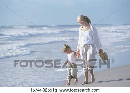 Mother walking with her daughter on the beach View Large Photo Image Stock Image - Mother walking with her daughter on the beach. Fotosearch