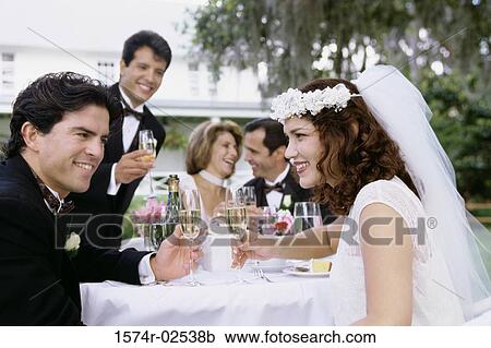 Stock Image - Newlywed couple and their friends toasting with champagne. Fotosearch