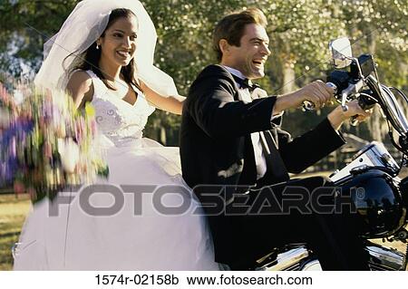 Stock Image - Newlywed couple riding on a motorcycle. Fotosearch