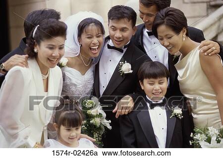 Stock Image - Newlywed couple smiling with their friends. Fotosearch