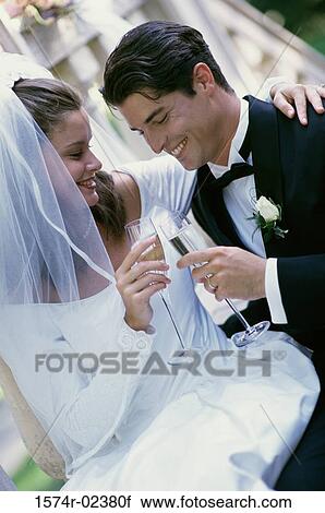 Stock Image - Newlywed couple toasting with glasses of champagne. Fotosearch