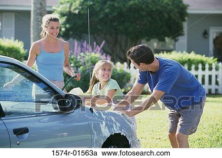 Stock Image - Parents and their daughter washing a car. Fotosearch