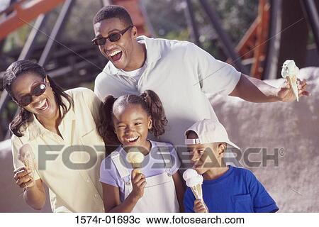Parents and their two children eating ice cream cones View Large Photo Image Stock Image - Parents and their two children eating ice cream cones. Fotosearch