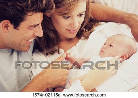 Stock Image - Parents carrying their baby boy. Fotosearch