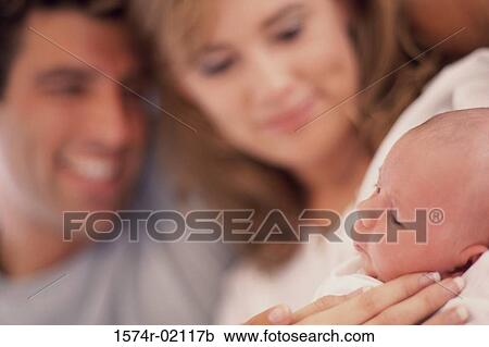 Stock Image - Parents carrying their baby boy. Fotosearch