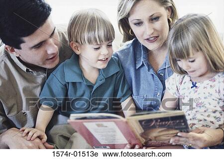 Parents reading a book with their son and daughter View Large Photo Image Stock Image - Parents reading a book with their son and daughter. Fotosearch