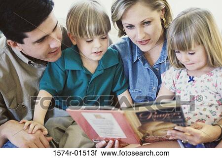 Parents reading a book with their son and daughter View Large Photo Image Stock Image - Parents reading a book with their son and daughter. Fotosearch