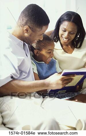 Parents reading a book with their daughter View Large Photo Image Stock Image - Parents reading a book with their daughter. Fotosearch