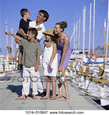 Parents standing with their children on a pier View Large Photo Image Stock Photo - Parents standing with their children on a pier. Fotosearch