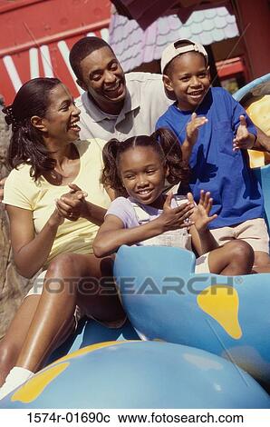 Parents with their son and daughter at an amusement park View Large Photo Image Stock Image - Parents with their son and daughter at an amusement park. Fotosearch