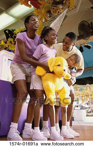 Stock Image - Parents with their son and daughter at an amusement park. Fotosearch