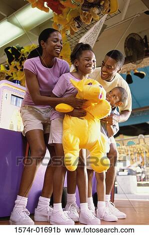 Stock Image - Parents with their son and daughter at an amusement park. Fotosearch