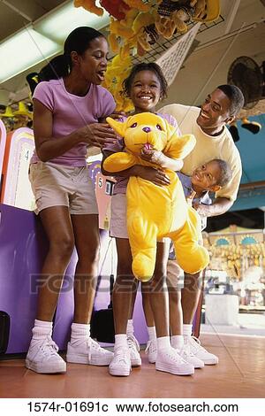 Stock Image - Parents with their son and daughter at an amusement park. Fotosearch