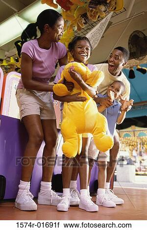 Stock Image - Parents with their son and daughter at an amusement park. Fotosearch