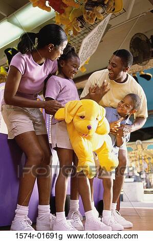 Stock Image - Parents with their son and daughter at an amusement park. Fotosearch