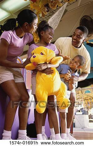 Stock Image - Parents with their son and daughter at an amusement park. Fotosearch
