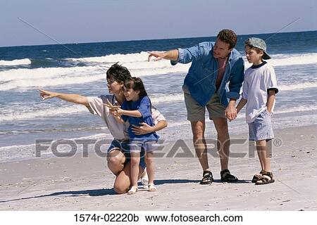 Stock Image - Parents with their son and daughter on the beach. Fotosearch