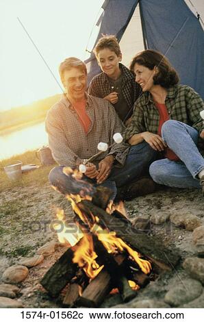 Parents with their son sitting in front of a campfire on the beach View Large Photo Image Stock Image - Parents with their son sitting in front of a campfire on the beach. Fotosearch