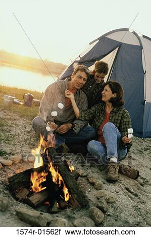 Parents with their son sitting in front of a campfire on the beach View Large Photo Image Stock Image - Parents with their son sitting in front of a campfire on the beach. Fotosearch