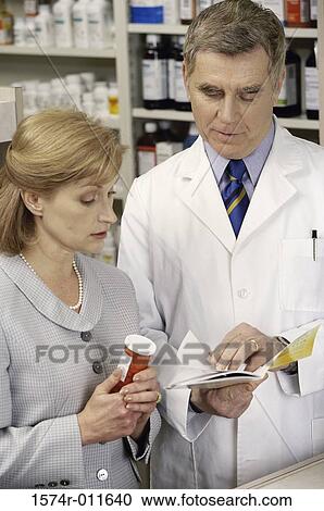 Stock Image - Pharmacist talking to a female patient. Fotosearch
