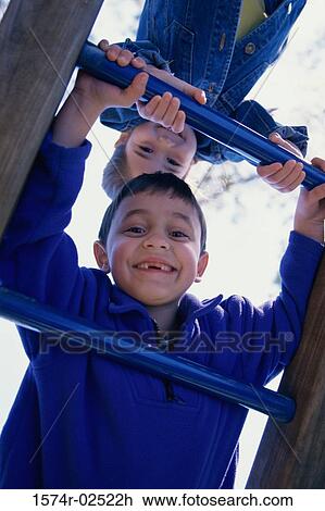 Portrait of a boy and a girl climbing on monkey bars View Large Photo Image Stock Image - Portrait of a boy and a girl climbing on monkey bars. Fotosearch