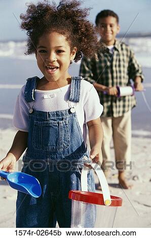 Portrait of a boy and a girl playing on the beach View Large Photo Image Stock Image - Portrait of a boy and a girl playing on the beach. Fotosearch