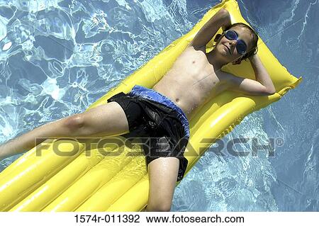 Portrait of a boy floating on a raft in a swimming pool View Large Photo Image Stock Image - Portrait of a boy floating on a raft in a swimming pool. Fotosearch