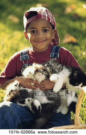 Stock Image - Portrait of a boy holding cats. Fotosearch
