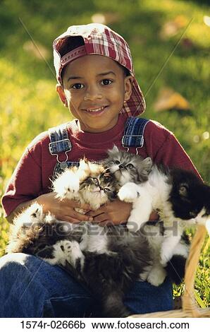 Stock Image - Portrait of a boy holding cats. Fotosearch