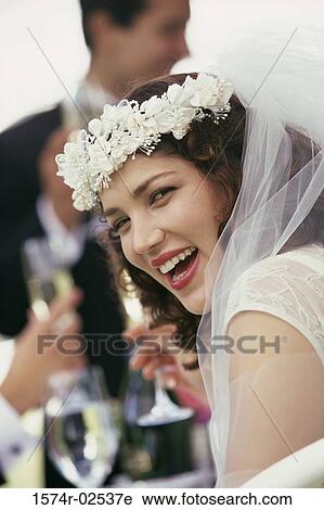 Stock Image - Portrait of a bride toasting with glasses of champagne. Fotosearch