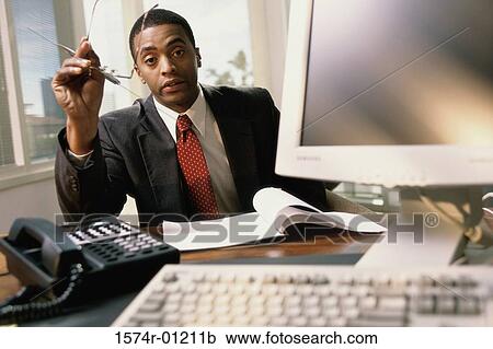 Stock Image - Portrait of a businessman at a desk. Fotosearch