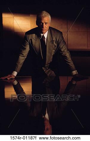 Portrait of a businessman leaning against a table View Large Photo Image Stock Image - Portrait of a businessman leaning against a table. Fotosearch