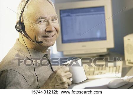 Portrait of a businessman wearing a headset and holding a cup View Large Photo Image Stock Image - Portrait of a businessman wearing a headset and holding a cup. Fotosearch