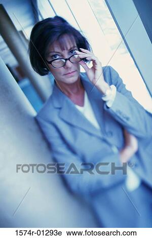 Stock Image - Portrait of a businesswoman adjusting her eyeglasses. Fotosearch