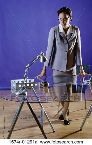 Portrait of a businesswoman leaning against a table View Large Photo Image Stock Image - Portrait of a businesswoman leaning against a table. Fotosearch