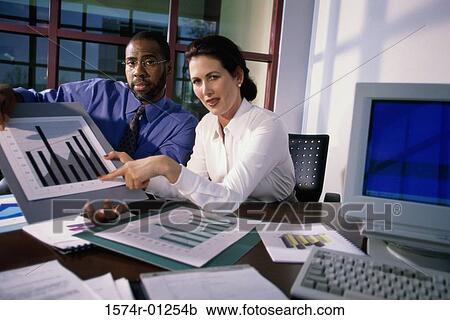 Stock Image - Portrait of a businesswoman pointing to a graph. Fotosearch