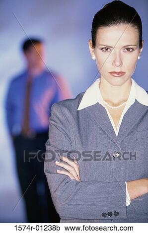 Stock Image - Portrait of a businesswoman with a businessman behind her. Fotosearch