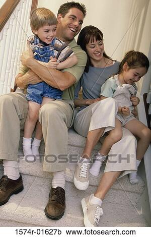 Portrait of a couple sitting on steps with their son and daughter View Large Photo Image Stock Image - Portrait of a couple sitting on steps with their son and daughter. Fotosearch