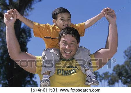 Portrait of a father carrying his son on his shoulders View Large Photo Image Stock Image - Portrait of a father carrying his son on his shoulders. Fotosearch