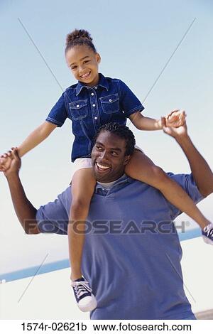 Portrait of a father carrying his daughter on his shoulders View Large Photo Image Stock Image - Portrait of a father carrying his daughter on his shoulders. Fotosearch