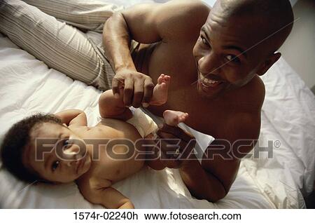 Portrait of a father holding his baby boy's feet View Large Photo Image Stock Image - Portrait of a father holding his baby boy's feet. Fotosearch