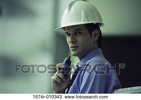 Portrait of a foreman standing holding a mobile phone View Large Photo Image Stock Image - Portrait of a foreman standing holding a mobile phone. Fotosearch